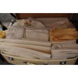 A huge quantity of vintage and antique bed linen in a suitcase, including flat sheets and pillow