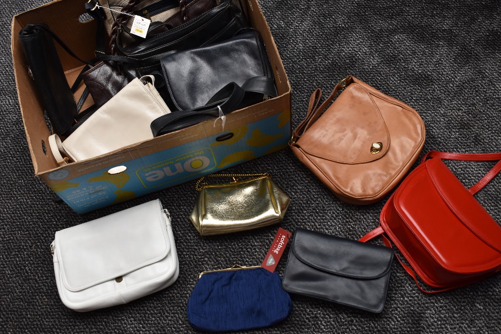 A box of good quality modern and retro handbags , some with tags still attached, including Tula