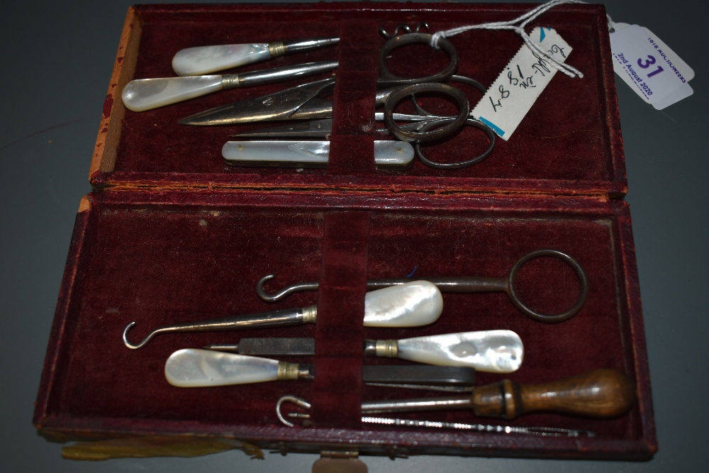 A Late 19th century manicure set containing scissors , button hooks and similar, five items having