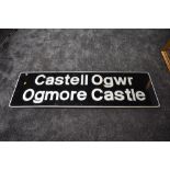 A wooden sign, Castell Ogwr Ogmore Castle, silver lettering and border on black background, 59 x