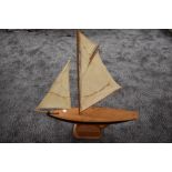 A hand made wooden model sail boat on stand