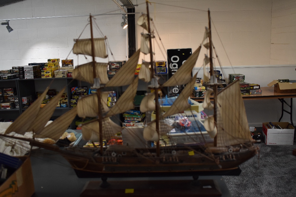 A wooden hand made model sail boat having extensive rigging and on plinth