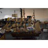 A wooden hand made model sail boat having extensive rigging and on plinth