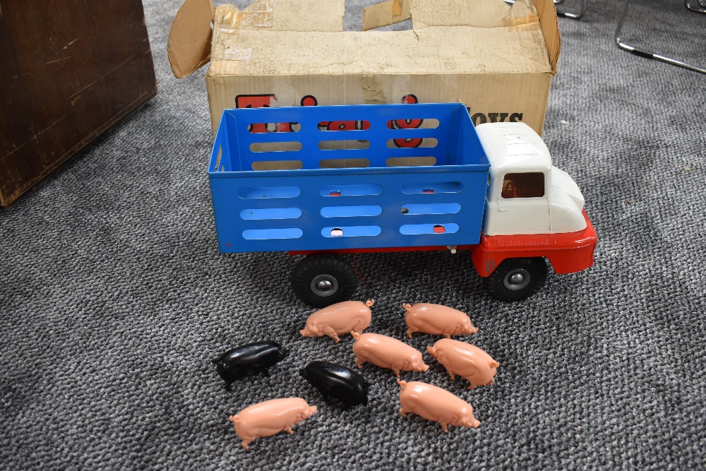 A Triang tin plate Farm Lorry with 6 pink and two black plastic pigs,having blue body, white cab and