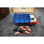 A Triang tin plate Farm Lorry with 6 pink and two black plastic pigs,having blue body, white cab and
