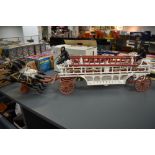 A vintage cast metal model of a Horse Drawn Fire Ladder Tender, three prancing horses, made in the