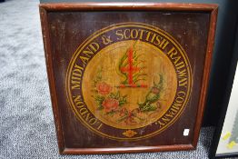 A framed London Midland & Scottish Railway Company wooden painted plaque having thistle decoration