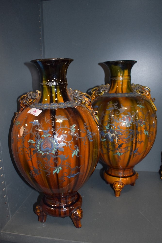 A pair of oriental possibly Japanese mantle vase or urns with three footed base and character seal