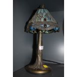 A tiffany style leaded light and brass effect base with dragonfly design