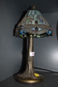 A tiffany style leaded light and brass effect base with dragonfly design