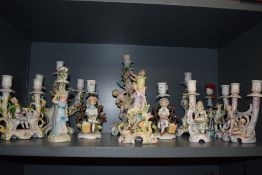 An impressive collection of hard paste and bisque antique and later figural candle sticks and