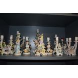 An impressive collection of hard paste and bisque antique and later figural candle sticks and