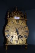 A brass cased lantern clock signed to back W&H Seh with chased floral design standing approx 35 cm