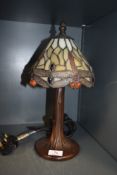 A stained glass Tiffany style desk lamp, having metal tree effect stand.