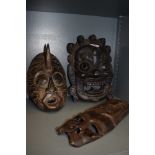 Three carved wooden masks.