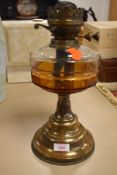 A vintage oil burning light or lamp base with glass well and brass base