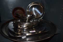 A collection of large metal platters,plates, bowls and similar.