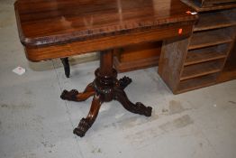 A William IV Rosewood fold over tea table, hollow section under top, on central turned column over