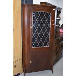 An early 20th Century stained frame corner display with lower cupboard section