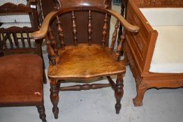 An early 20th Century oak elbow chair of traditional form, similar to smokers bow