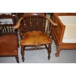 An early 20th Century oak elbow chair of traditional form, similar to smokers bow