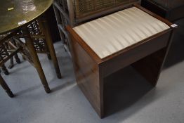 An early 20th Century piano or sewing stool with compartment below drop in seat