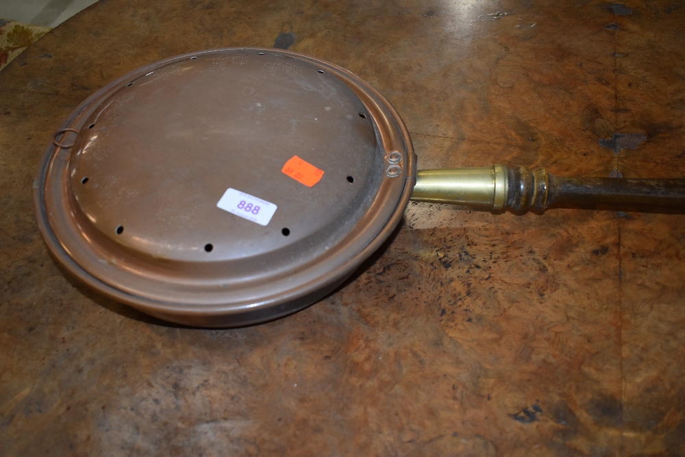 A traditional copper warming pan, with brass mount