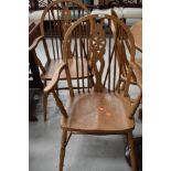 A pair of traditional light stain wheel back carver chairs