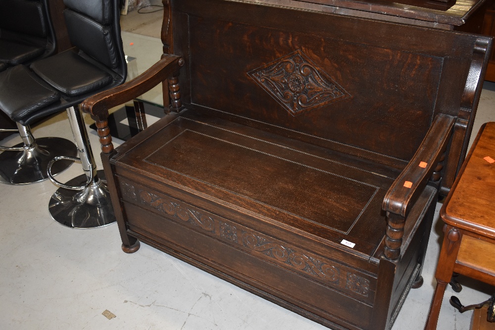 A traditional early 20th Century oak monks bench, width approx. 117cm