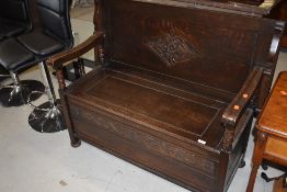 A traditional early 20th Century oak monks bench, width approx. 117cm