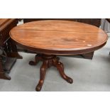 A Victorian mahogany loo style table, oval top over quadruple carved splay legs and scroll feet,