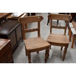 A pair of 19th Century stripped rail back dining chairs having solid seats