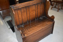 A traditional oak box settle, by Titchmarsh and Goodwin, labelled Siesta, retailed by NH Chapman and