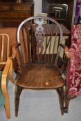 A traditional oak wheelback armchair, width approx 56cm