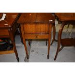 An early 20th Century oak sewing box on square tapered legs and spade feet, includes haberdashery