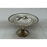 A small silver tazza having pierced decoration to rim of plain bowl on circular stepped pedestal,