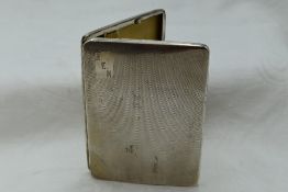 A white metal cigarette case stamped sterling silver having a slide clasp and engine turned