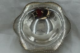 A silver pedestal bowl having decorative shaped rim and engraved swag decoration to bowl on circular
