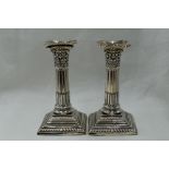 A pair of silver candle sticks of Corinthian column style having removable sconces, fluted columns