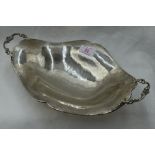 A white metal table bowl of shaped boat form having moulded handles, plannished finish and bracket