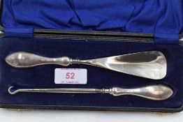 A cased silver shoe horn and button hook of plain form, Birmingham 1920, Vale & St John Ltd