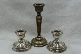 A pair of silver candle sticks of squat form, Birmingham 1976, W I Broadway, and a single silver