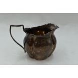 A small Victorian silver cream jug of goad form having beaded decoration to rim and handle, marks