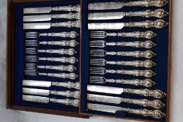 A mahogany canteen of Victorian silver handled dessert knives and forks (12 piece setting) having