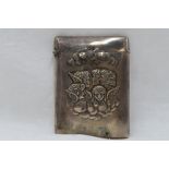 An Edwardian silver card holder of plain form having moulded cherubic decoration to front and hinged