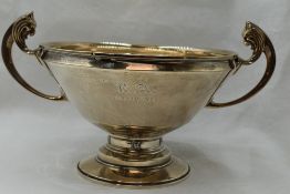 An Art Deco style bowl of plain form having inscription to side, lion mask loop handles and lion