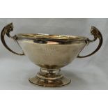 An Art Deco style bowl of plain form having inscription to side, lion mask loop handles and lion