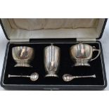 A cased silver three piece cruet set having blue glass liners, Birmingham 1917, William Suckling