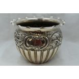 An Edwardian silver jardiniere having gadrooned decoration with repousse rose and scroll band,