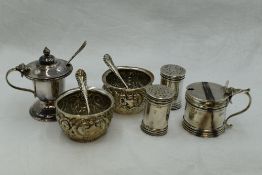 A selection of HM silver cruet items including a pair of pepperettes, a pair of salts and two lidded